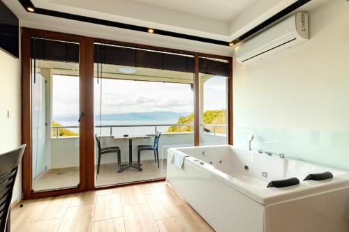 a bathroom with a tub and a balcony with a table at Apartments BRAVO in Ohrid