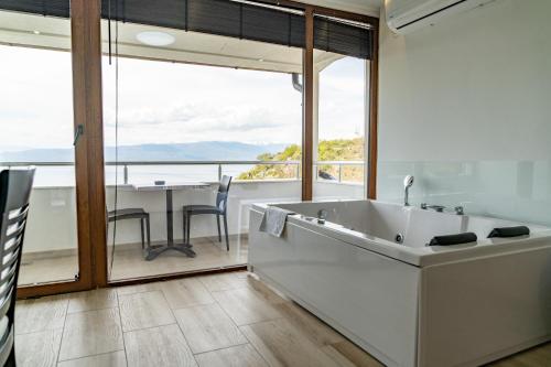 a bathroom with a tub and a dining room with a table at Apartments BRAVO in Ohrid