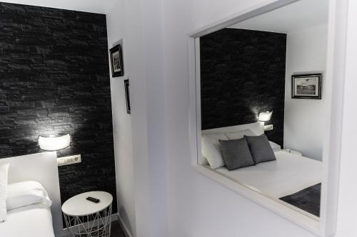 a mirror in a bedroom with a white bed and a bed at Casa da Vasca in Malpica