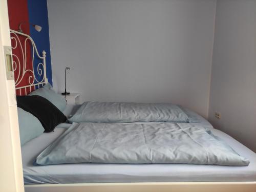 Duas camas num pequeno quarto com uma parede branca em FeWo Seepferdchen em Emden