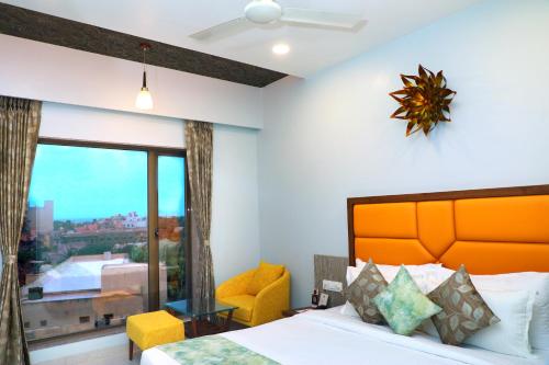 a bedroom with a bed and a large window at HOTEL THE GRANDLADHUKARA in Dwarka