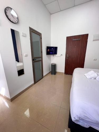 a bedroom with a bed and a clock on the wall at Paris Square Apartments Downtown in Haifa