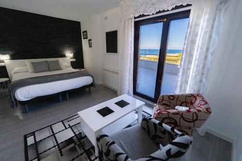 Un dormitorio con una cama y vista al mar. en Casa da Vasca, en Malpica de Bergantiños
