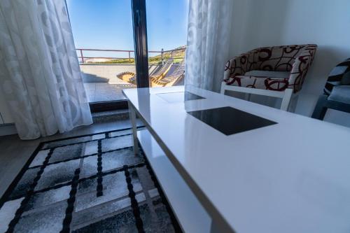 a living room with a white table and a window at Casa da Vasca in Malpica
