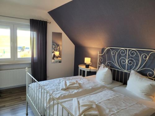 ein Schlafzimmer mit einem weißen Bett und einem Fenster in der Unterkunft Fewo am Yachthafen in Harlesiel