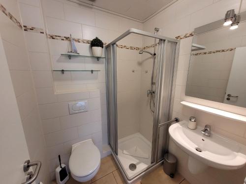 uma casa de banho com um chuveiro, um WC e um lavatório. em Fewo am Yachthafen em Harlesiel