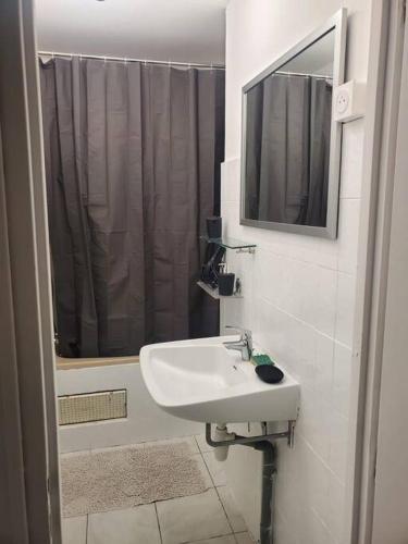 une salle de bain blanche avec un lavabo et une douche dans l'établissement Un petit coin de paradis, à Gavarret