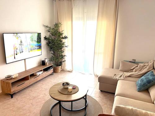 a living room with a couch and a tv at Casa Oikos - La Cala de Mijas in La Cala de Mijas