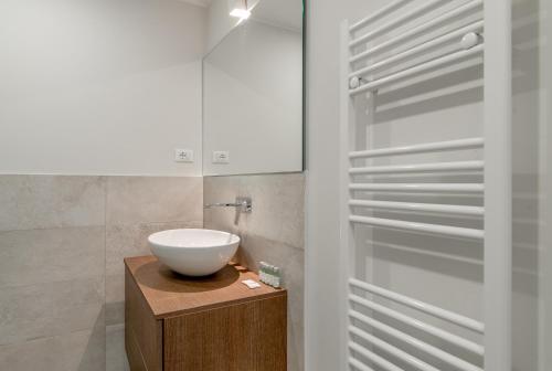 La salle de bains est pourvue d'un lavabo blanc sur un comptoir en bois. dans l'établissement metro, stazioni, palagiustizia: Il cielo su Torino, à Turin