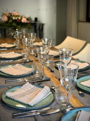 a wooden table with plates and glasses and napkins at Felix - Maison d'hôtes in Néffiès
