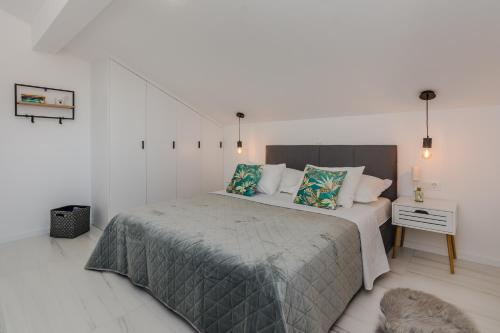 sypialnia z dużym łóżkiem w białym pokoju w obiekcie Apartment Redibo w mieście Privlaka