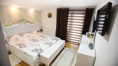 een kleine slaapkamer met een bed en een televisie bij Casa Ryn Navodari in Năvodari