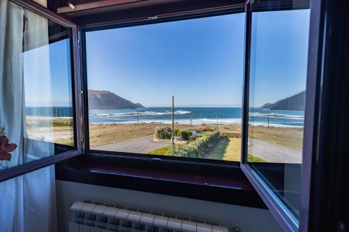 a room with a window with a view of the ocean at Casa da Vasca in Malpica
