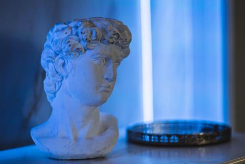 a bust of a woman sitting on a table next to a coin at BELVEDERE Luxury Apartment, view on the Lucca Walls in Lucca