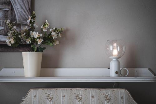 a table with a candle and a vase with flowers at BELVEDERE Luxury Apartment, view on the Lucca Walls in Lucca