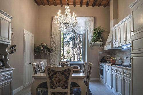 a kitchen with a dining table and a chandelier at BELVEDERE Luxury Apartment, view on the Lucca Walls in Lucca