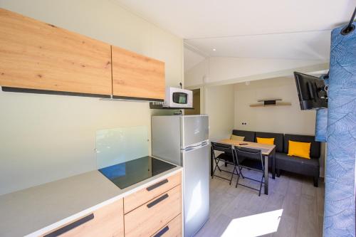eine Küche mit einem Kühlschrank und einem Tisch mit Stühlen in der Unterkunft Les Eaux Chaudes in Digne-les-Bains