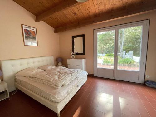 une chambre avec un lit et une porte coulissante en verre dans l'établissement Maison avec accès direct à la plage, 2 terrasses, jardin clos, 3 chambres, parking privé à La Guérinière - FR-1-224B-492, à La Guérinière