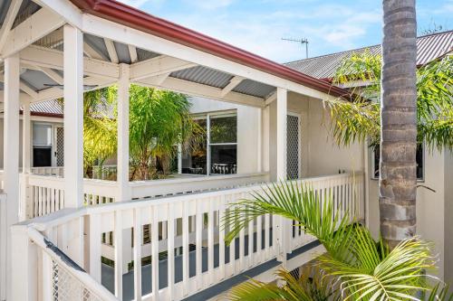 a white front porch of a house with palm trees at Central and modern 2 bedroom unit at Smugglers in Victor Harbor