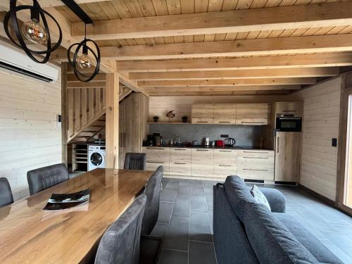 une salle à manger avec une table et des chaises en bois dans l'établissement Chalet L'Ôbresse, à La Bresse