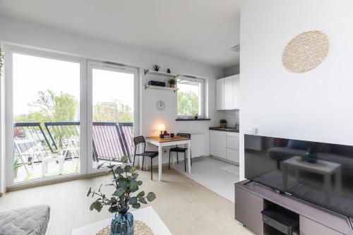 a kitchen and living room with a table and a television at SuperApart Mińska 25c in Warsaw