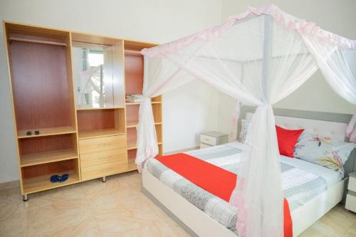 a bedroom with a bed with a canopy at The city Block Apartment in Bujumbura