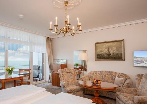 un soggiorno con letto e lampadario pendente di Strandhotel Monbijou GmbH garni a Westerland