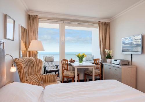 a hotel room with a bed and a table and chairs at Strandhotel Monbijou GmbH garni in Westerland (Sylt)