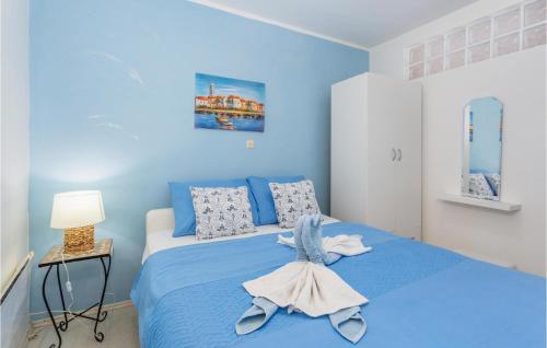 a blue bedroom with a bed with towels on it at Nice Apartment In Stara Baska With Wifi in Stara Baška