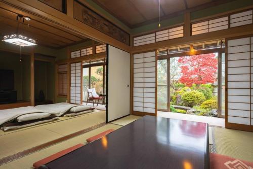 een kamer met een bed en een groot raam bij 6 min walk from JR. Entire Traditional House w/ Zen Garden 