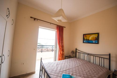 a bedroom with a bed and a large window at Pantelis Apartments in Agios Georgios