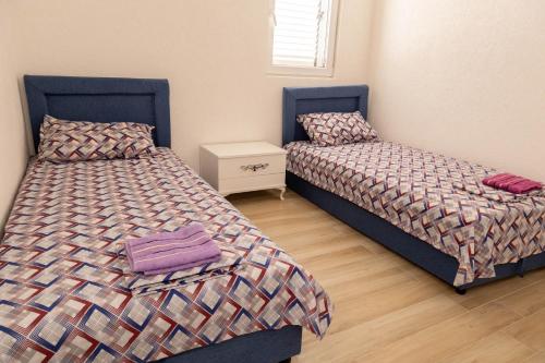 two beds sitting next to each other in a bedroom at Apartmani Marojević, Bar in Bar