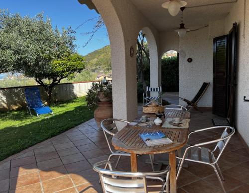 uma mesa de madeira e cadeiras num pátio em Villa Bartali em Marina di Fuscaldo