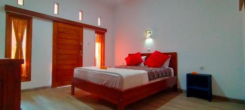 a bedroom with a bed with red pillows at Tunjung guest house lovina beach in Buleleng