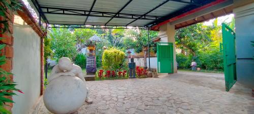 an entrance to a building with a statue sitting in the doorway at Tunjung guest house lovina beach in Buleleng