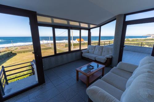 a living room with couches and a view of the ocean at Casa da Vasca in Malpica