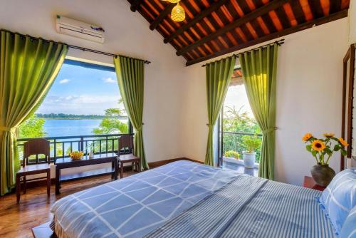 a bedroom with a bed and a view of the water at Calm House 2 HOSTEL in Hoi An