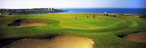 an aerial view of a golf course near the ocean at Studio avec terrasse et jardin à 100 m de la plage in Ploemeur
