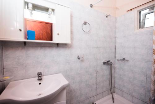 a bathroom with a sink and a toilet and a shower at Pantelis Apartments in Agios Georgios
