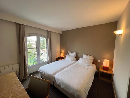 une chambre d'hôtel avec un lit et une fenêtre dans l'établissement Le Pré Saint Germain, à Louviers