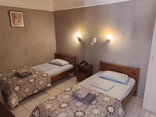 アイギナにあるMiranta Hotel - Apartments & Studiosのベッド2台、壁掛け電話が備わる客室です。