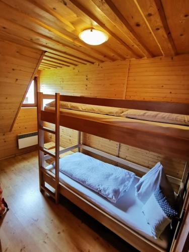 a room with two bunk beds in a cabin at Drevenica Západné Tatry s kúpacou kaďou a krbom in Žiar