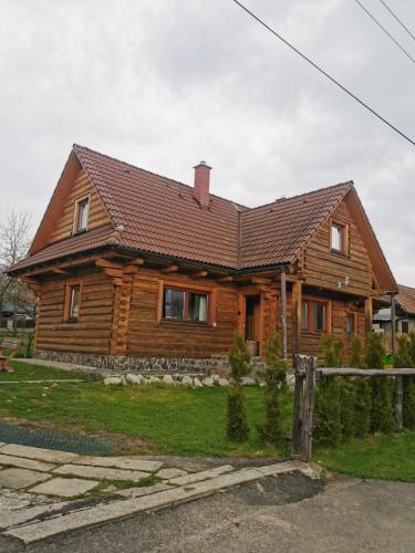 a wooden house with a fence in front of it at Drevenica Západné Tatry s kúpacou kaďou a krbom in Žiar