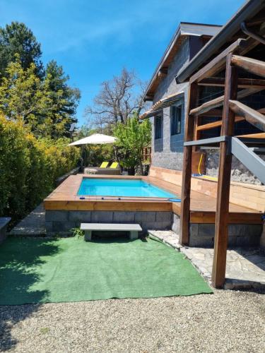 einen Pool mit grünem Rasen neben einem Haus in der Unterkunft Villa Gorna in Trecastagni