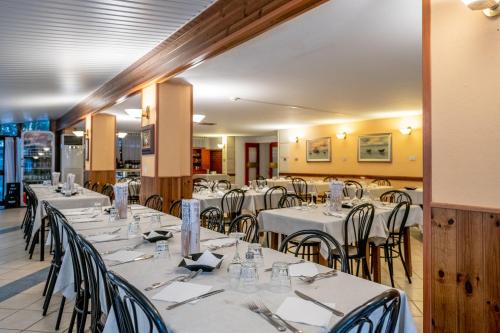 a dining room with white tables and chairs at Real Park Hotel in Cavi di Lavagna