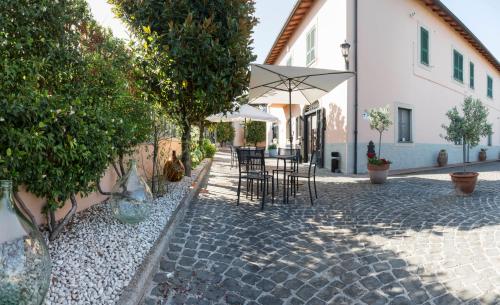 a patio with chairs and a table with an umbrella at Country House nella Winery in Frascati