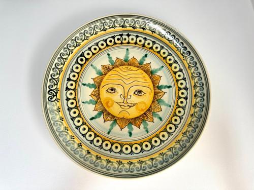 a plate with a drawing of a sun on it at Terrazza Diomede Manfredi Homes&Villas in Manfredonia