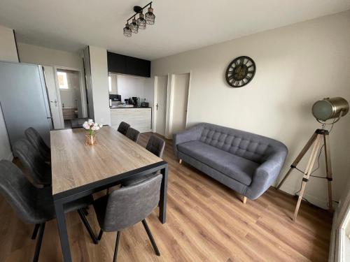 uma sala de estar com uma mesa e um sofá em Appartement vu mer em La Faute-sur-Mer