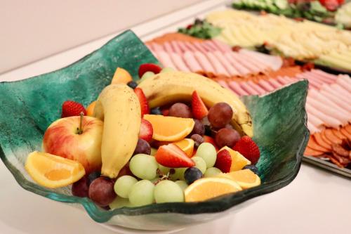 a plate filled with fruit on a table at Hotel La Riva in Siófok
