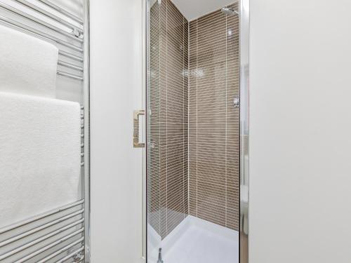 a shower with a glass door in a bathroom at Humbug House in Lower Soudley